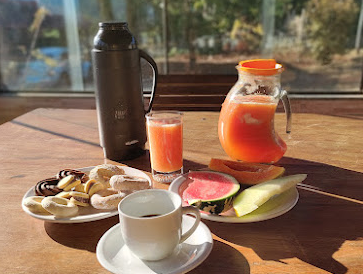 Mesa de café da manhã com suco, frutas e biscoitos caseiros