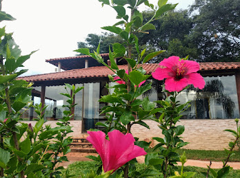 Fachada da pousada com flores cor-de-rosa